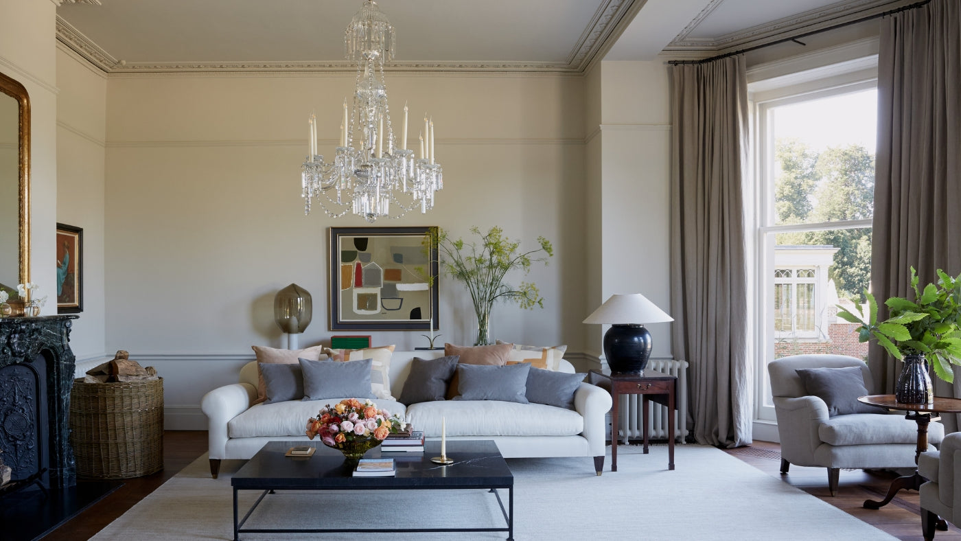 guest living room with natural light white couch and chandelier