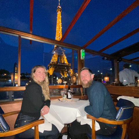 Diana and Tim Kerins at table on Le Calife Dinner Cruise Eiffel Tower in background