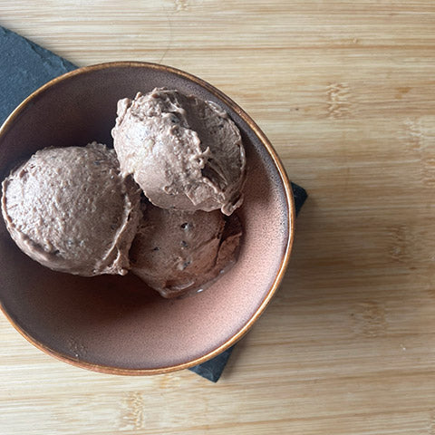 3 scoops of vegan banana & chocolate ice cream in a rustic bowl on a serving slate