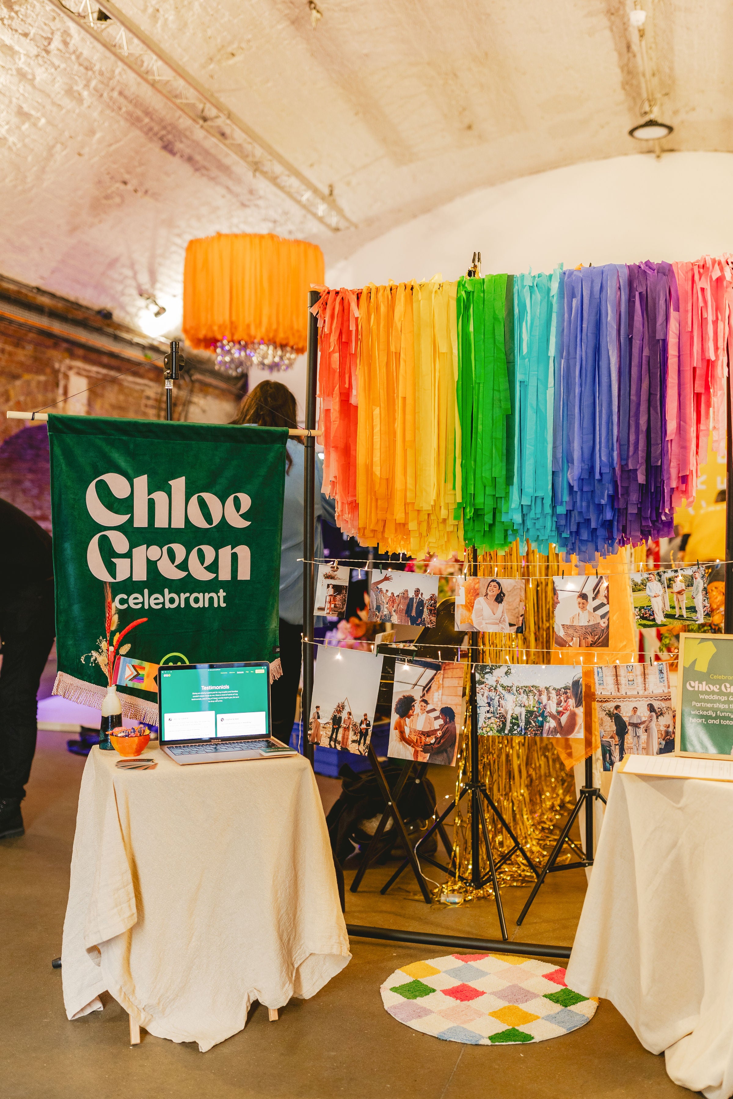Wedding show in London featuring celebrant Chloe Green's stand with rainbow tassels and fabric banner displaying her name.