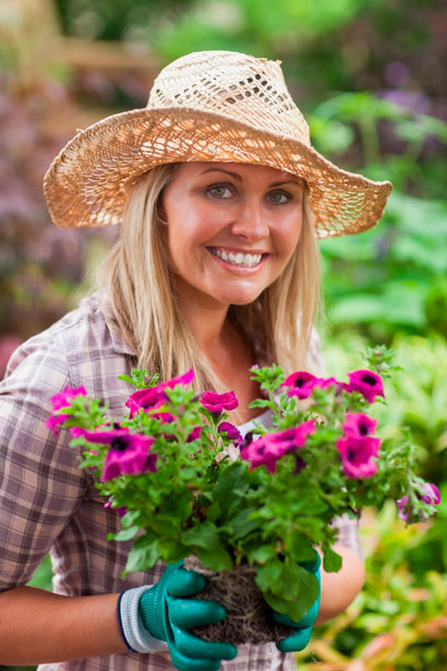 blonde woman with hat carrying petunias - Etshera