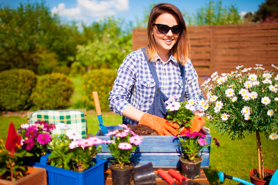 smiling woman wearing sunglasses gardening - Etshera