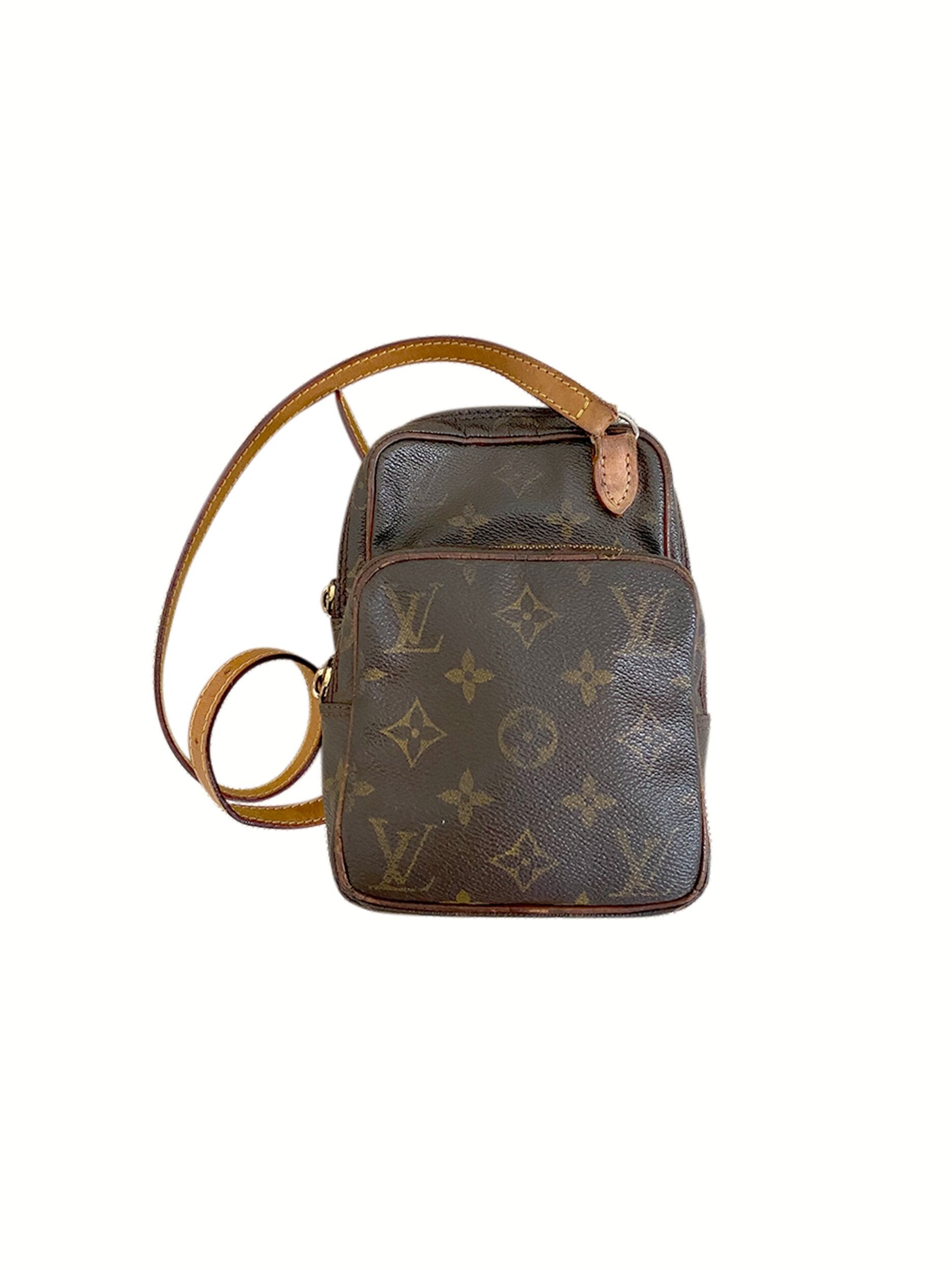 Louis vuitton bag with the brown and light brown monogram on one side, and  black and dark gray borders. made of leather and featuring a square shape  with the gold lv logo