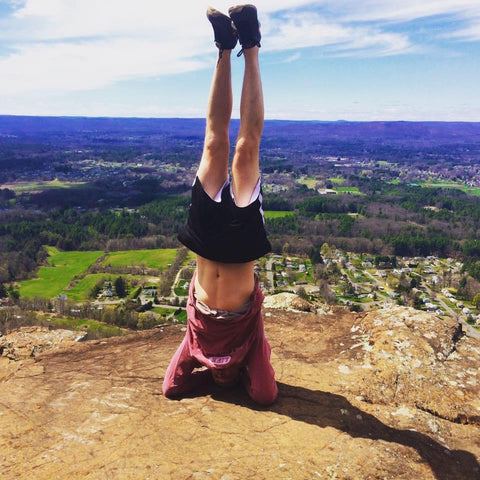 Amazonian SkinFood Founder Shane Lindner doing a yoga headstand on Mount Tom in Easthampton, MA