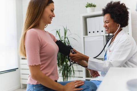 Female nurse checks blood pressure of a female patient