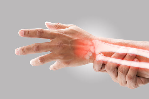 Man massaging pain in wrist, red and inflamed, graphic of wrist bones superimposed on top