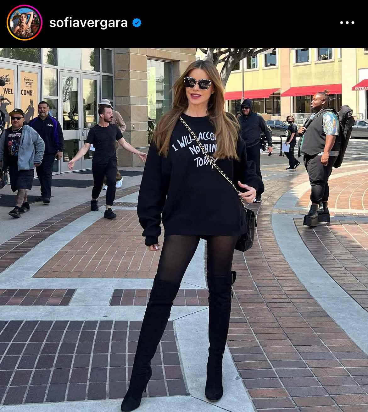 Sofia Vergara in black tights, sweatshirt, sunglasses, and thigh high boots