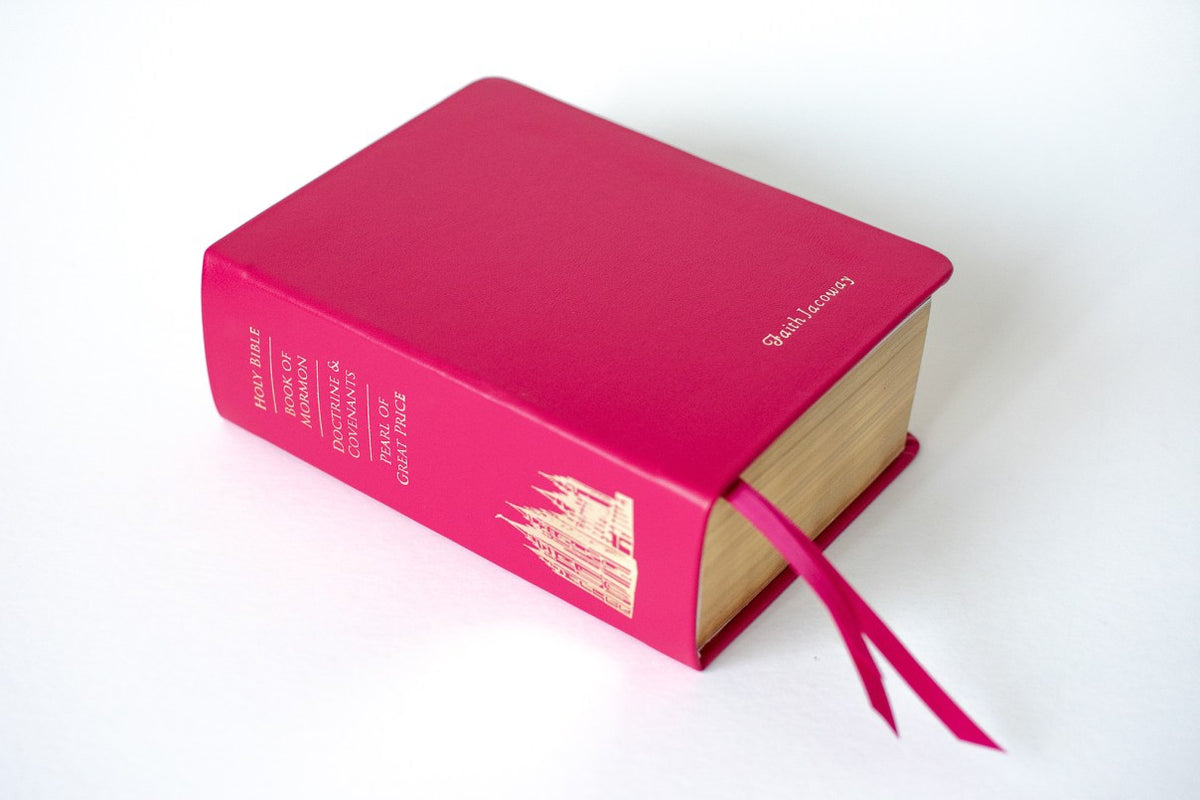 Leather Hot Pink Quad Engraved with Gold Lettering & Temple Embossing, in Front of a White Background | Custom LDS Scriptures & Rebinding Services | Color Scriptures