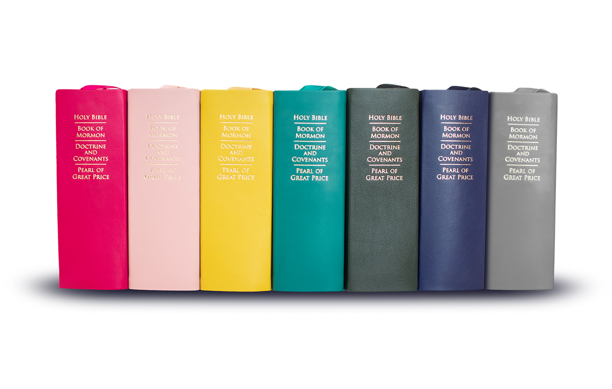 Stack of colored lds scriptures. Scripture colors include hot pink, pink, banana, jade, forest green, royal blue & gray. Colorful Basic Quads by Custom LDS Scriptures.