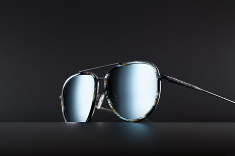 Aviator style glasses with matte black frames, silver lenses, and calico acetate rims