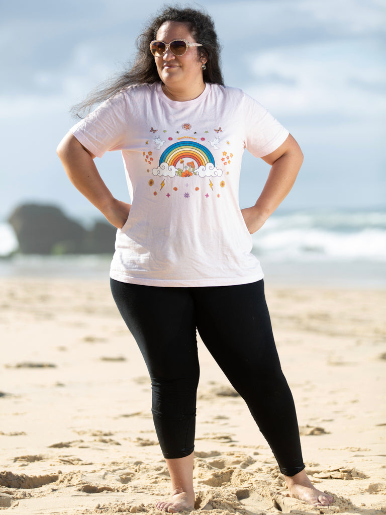 woman at the beach wearing a pink light tshirt with Sunkissed written on it | Raiana's Vibes