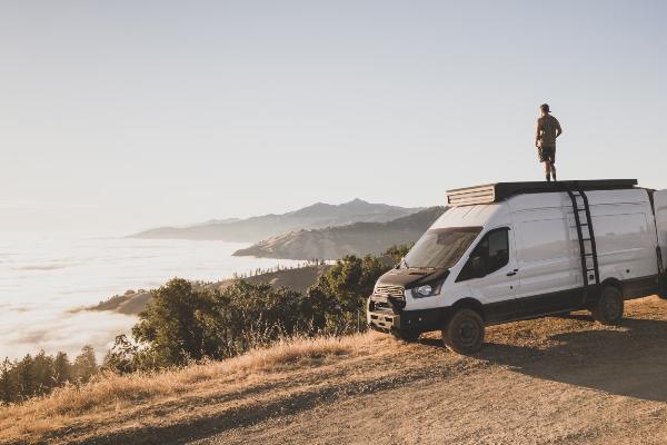 A man stands atop his RV, enjoying the astonishing view.png