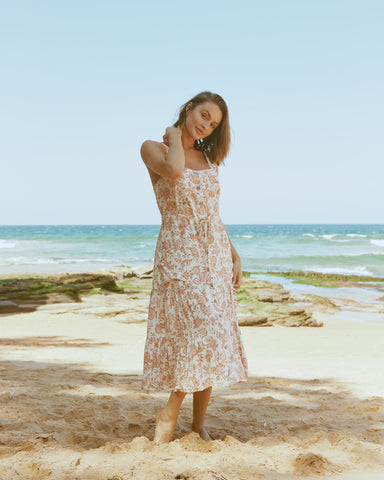 woman wearing a floral dress on a beach
