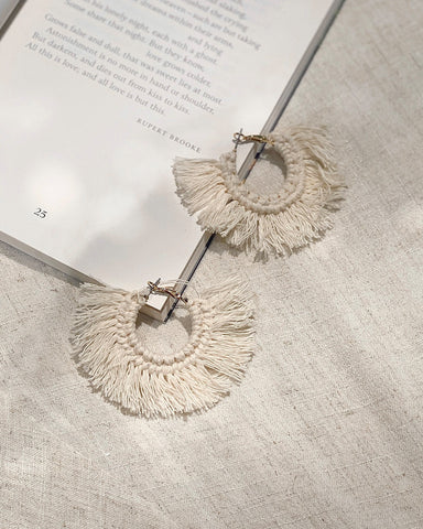a pair of earrings next to a page
