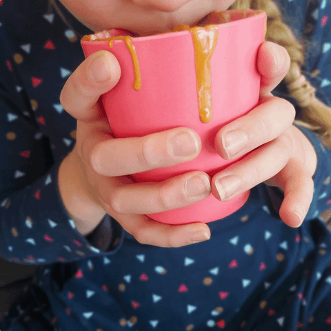 girl drinking a hot chocolate out of a pink cup