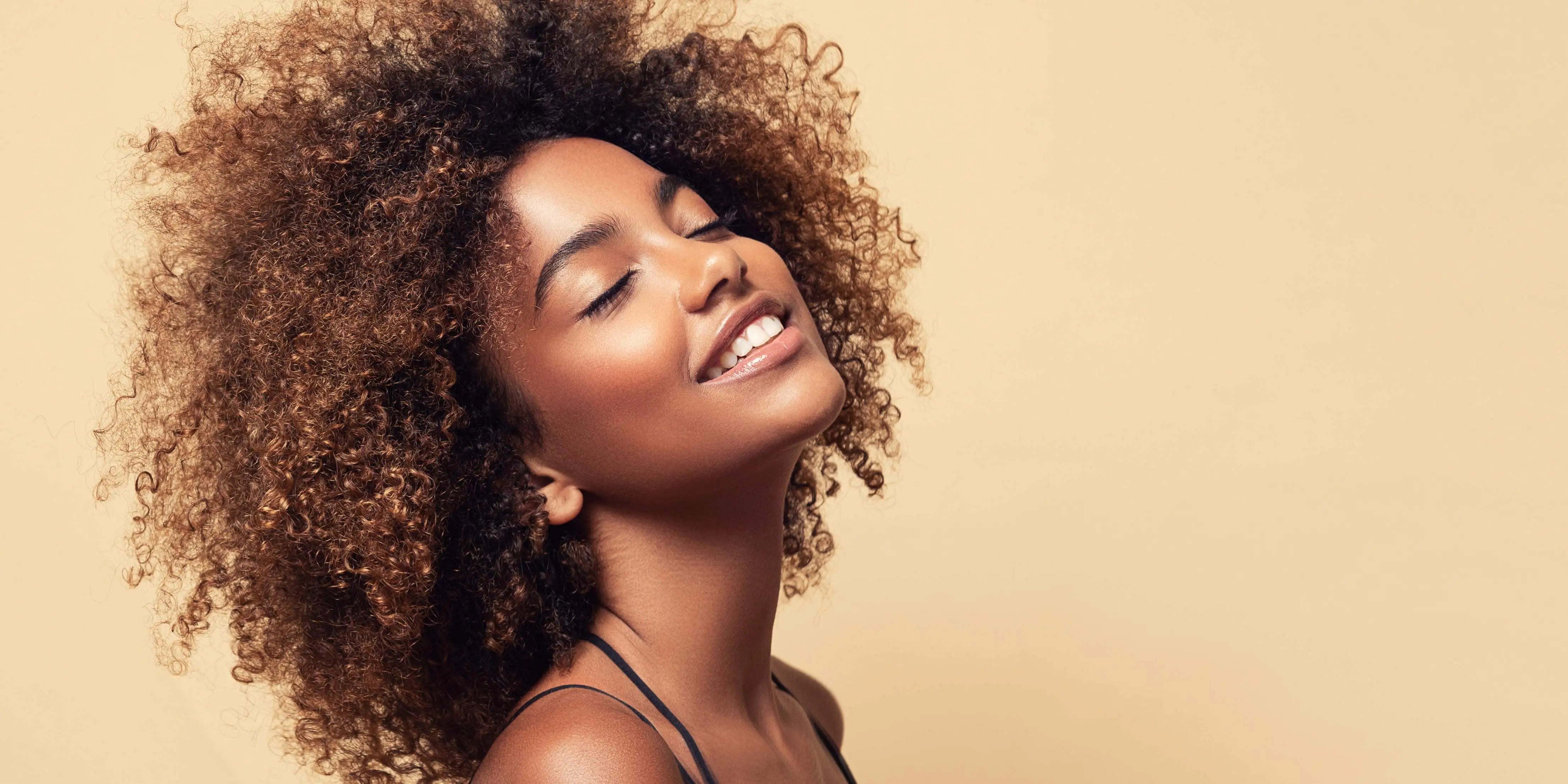 A woman with curly hairs and a beautiful smile