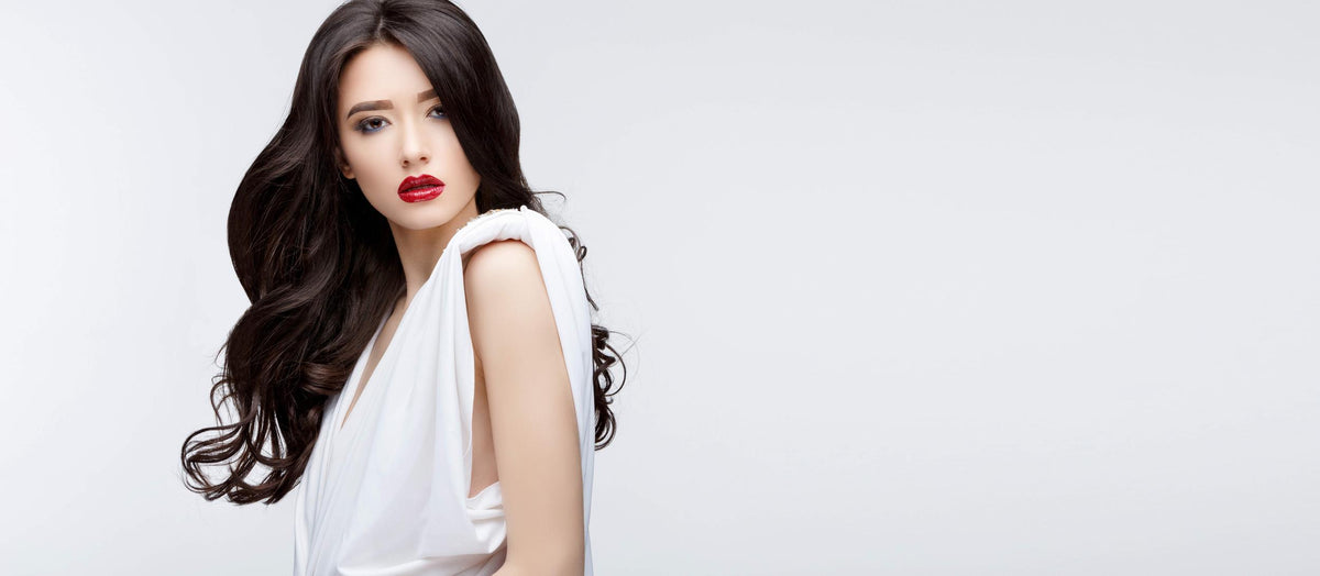 Long black haired woman modeling in a white dress
