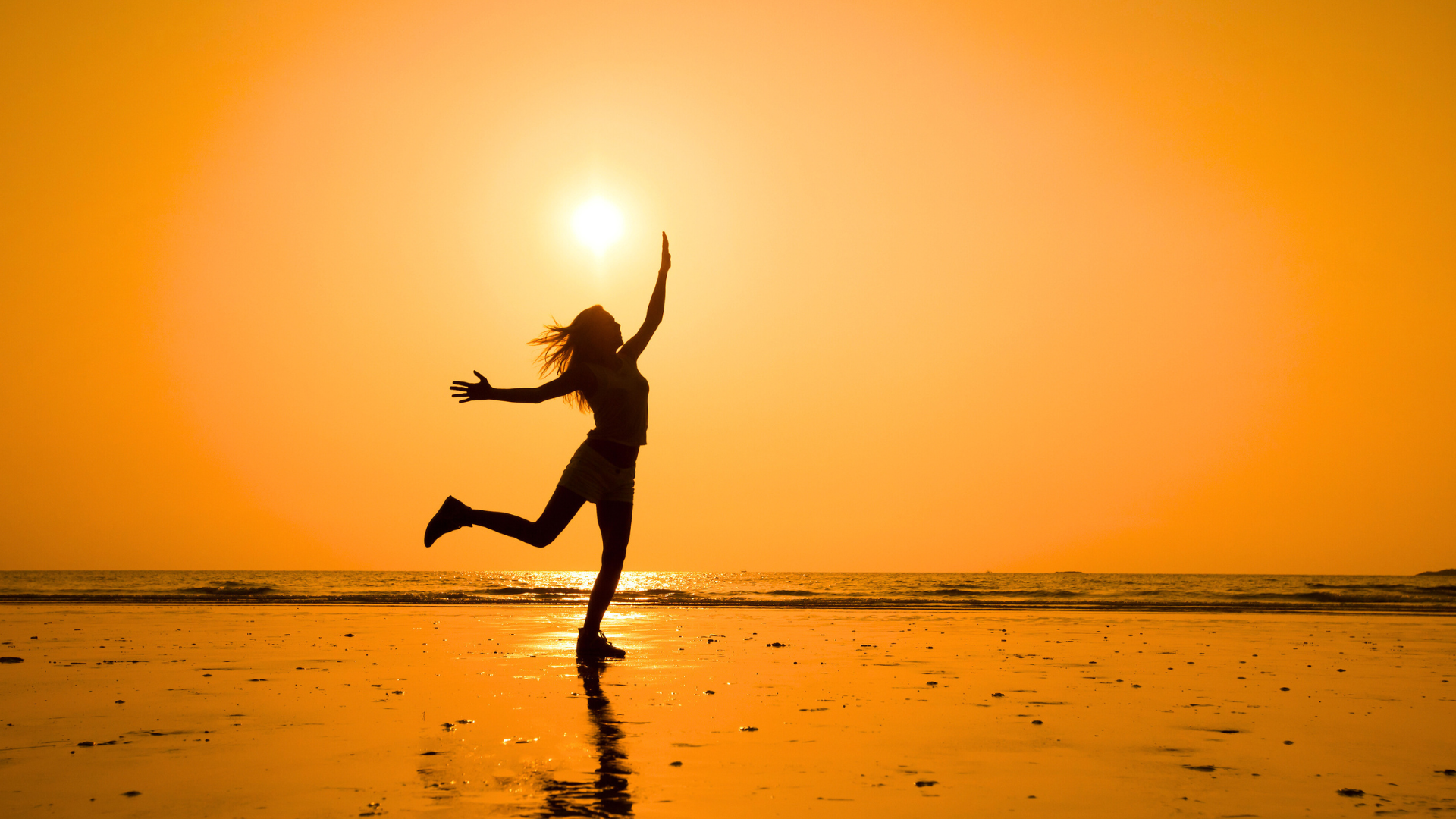 woman dancing near the seashore at sunset