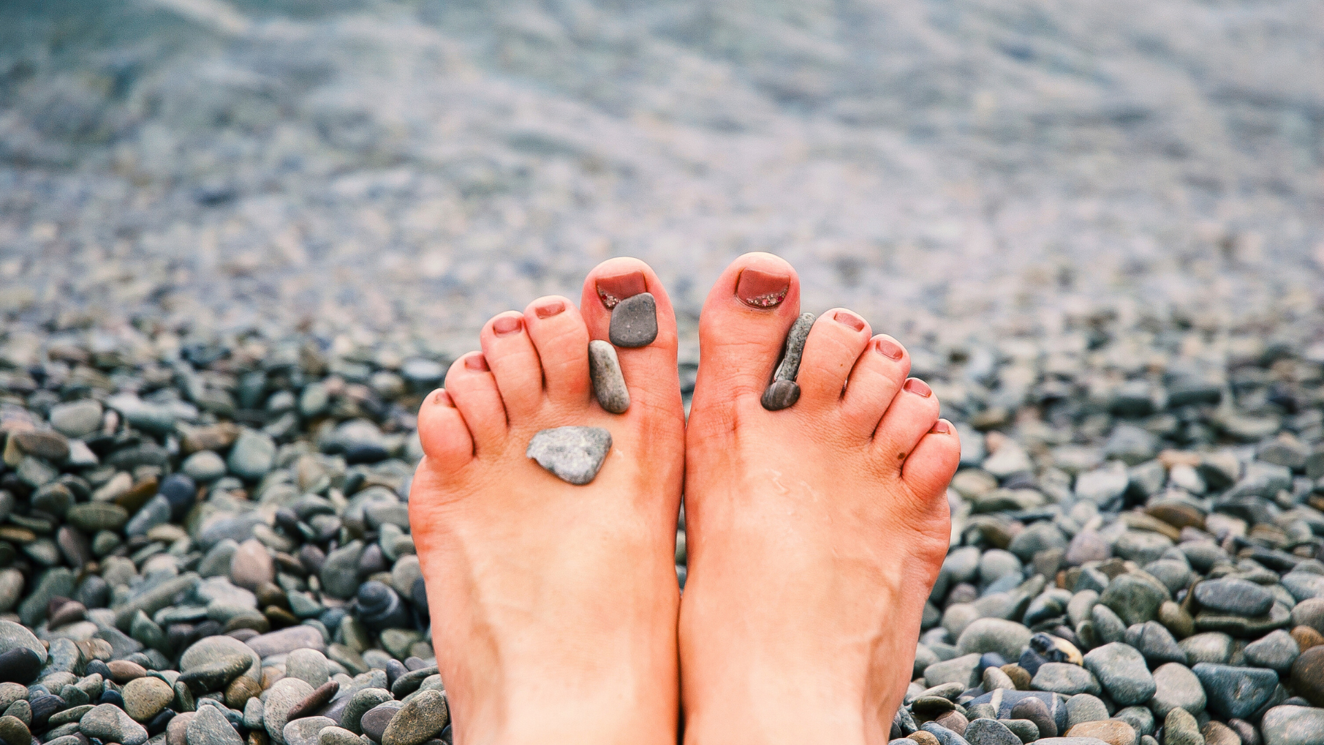 a person's bare feet beside the seashore