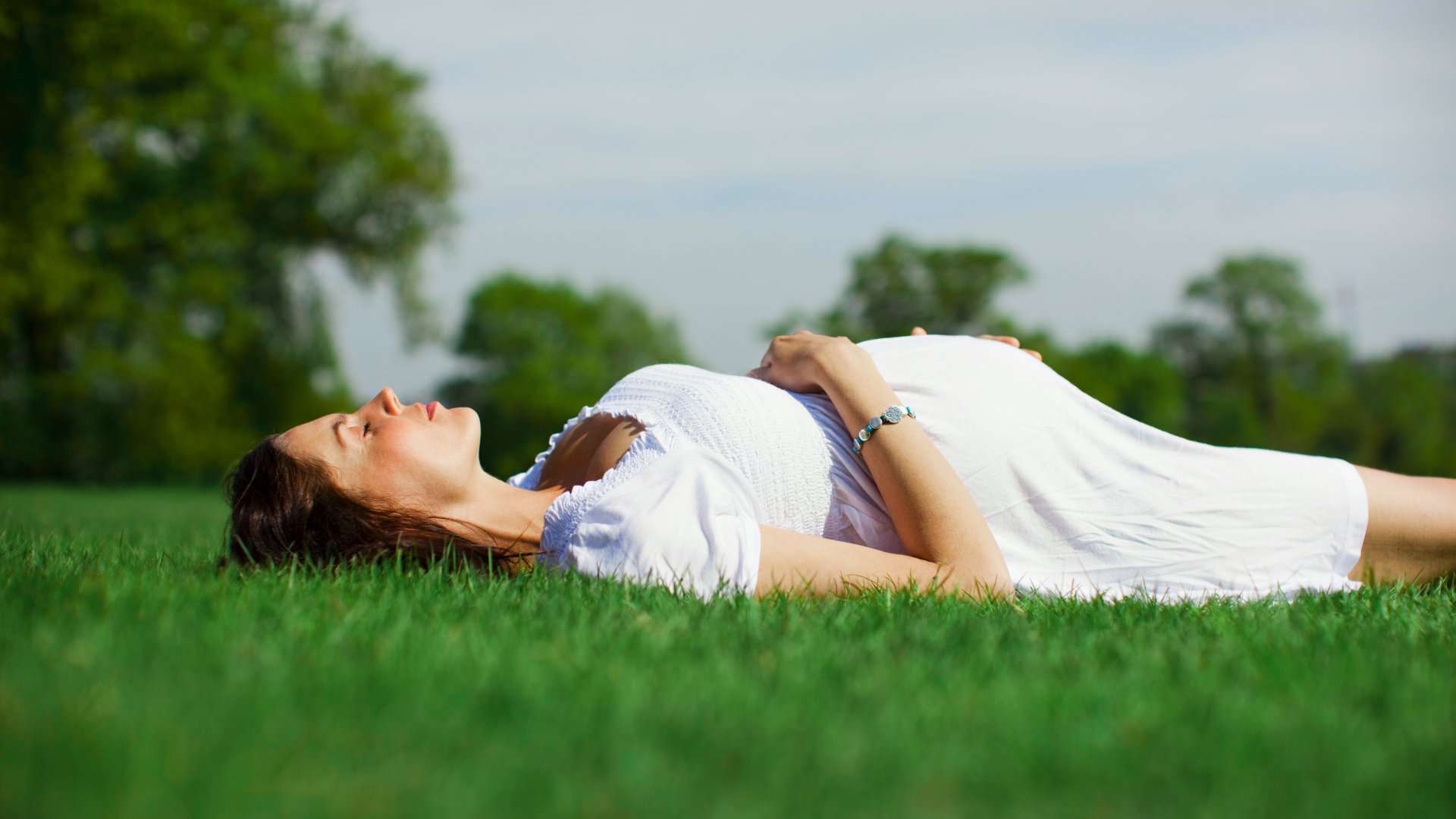 pregnant women lying on the grass field