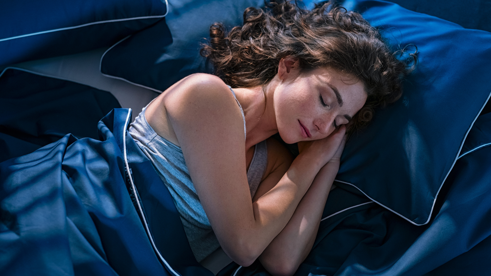 woman sleeping on the blue beddings