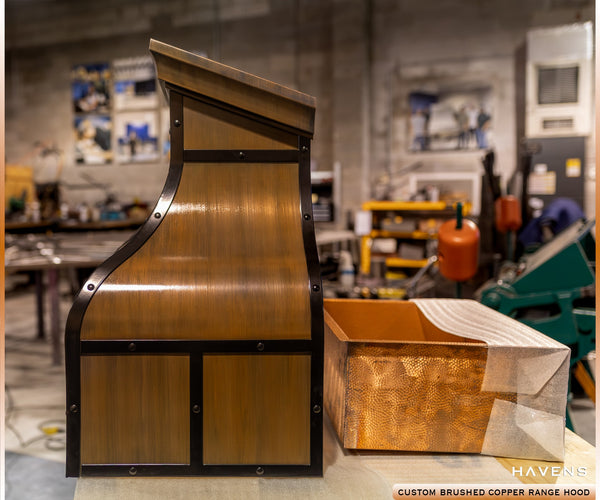 Custom copper range hood with black straps and matching sink