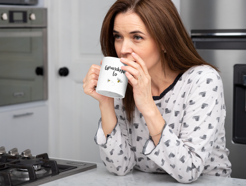 Woman Drinking Coffee from a Grandma to Bee mug