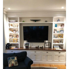 Custom wall piece with adjustable shelving, as well as five cabinets with five drawers. Shown in white.