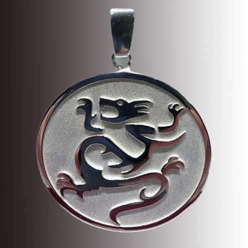 Silver round pendant with dragon engraved on dark background