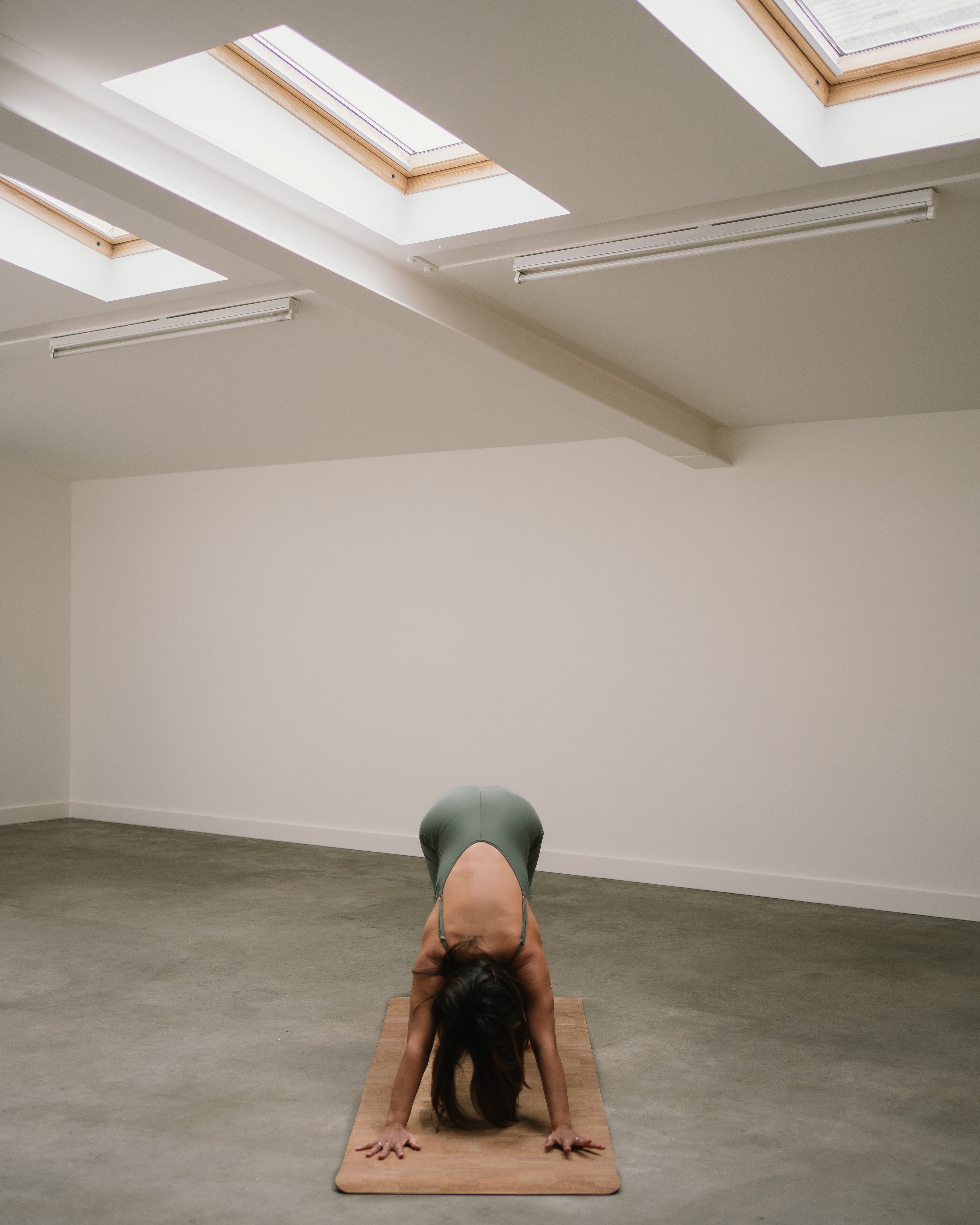 model doing downward facing dog on a noveme cork yoga mat