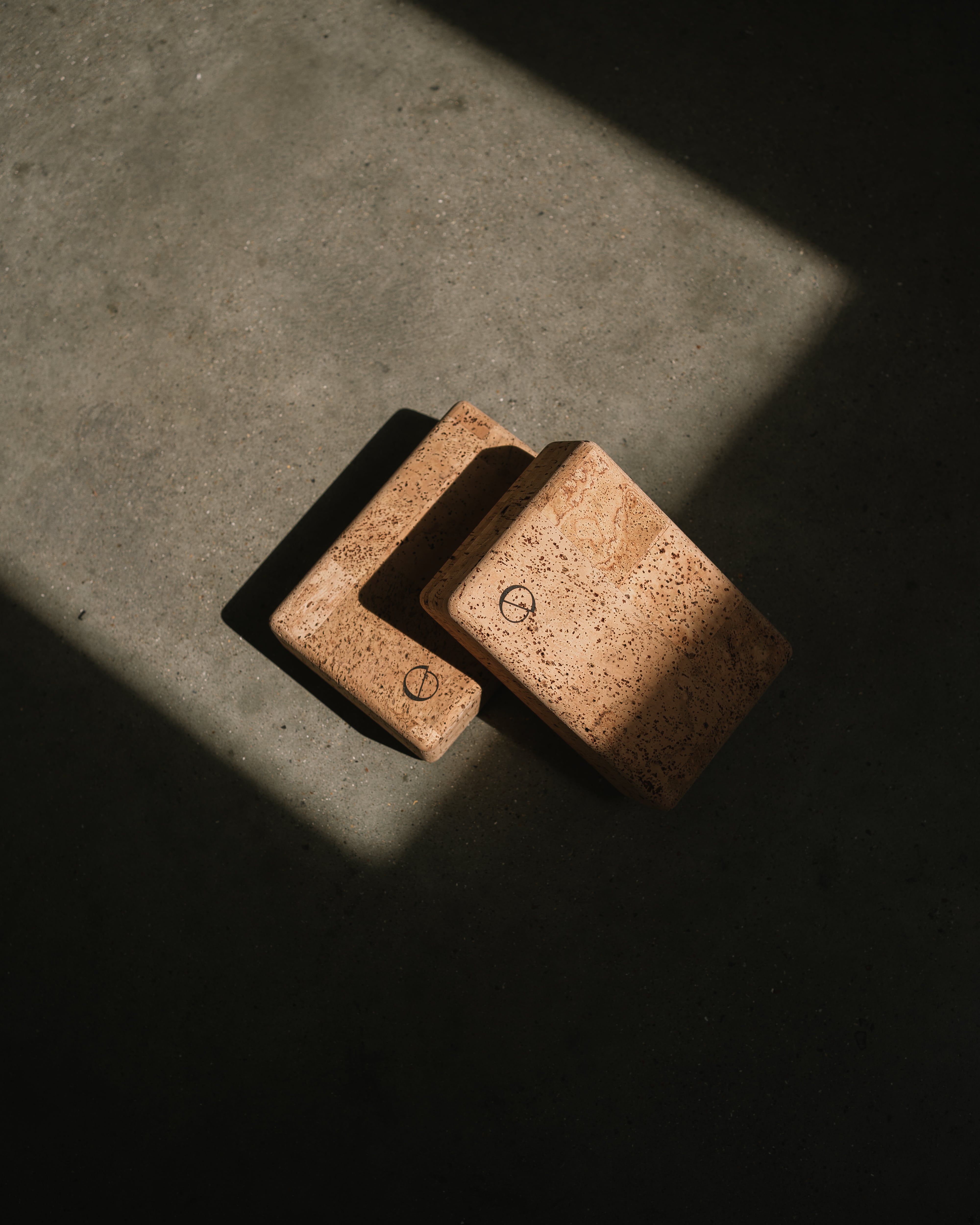 two noveme cork yoga blocks placed on a concrete floor