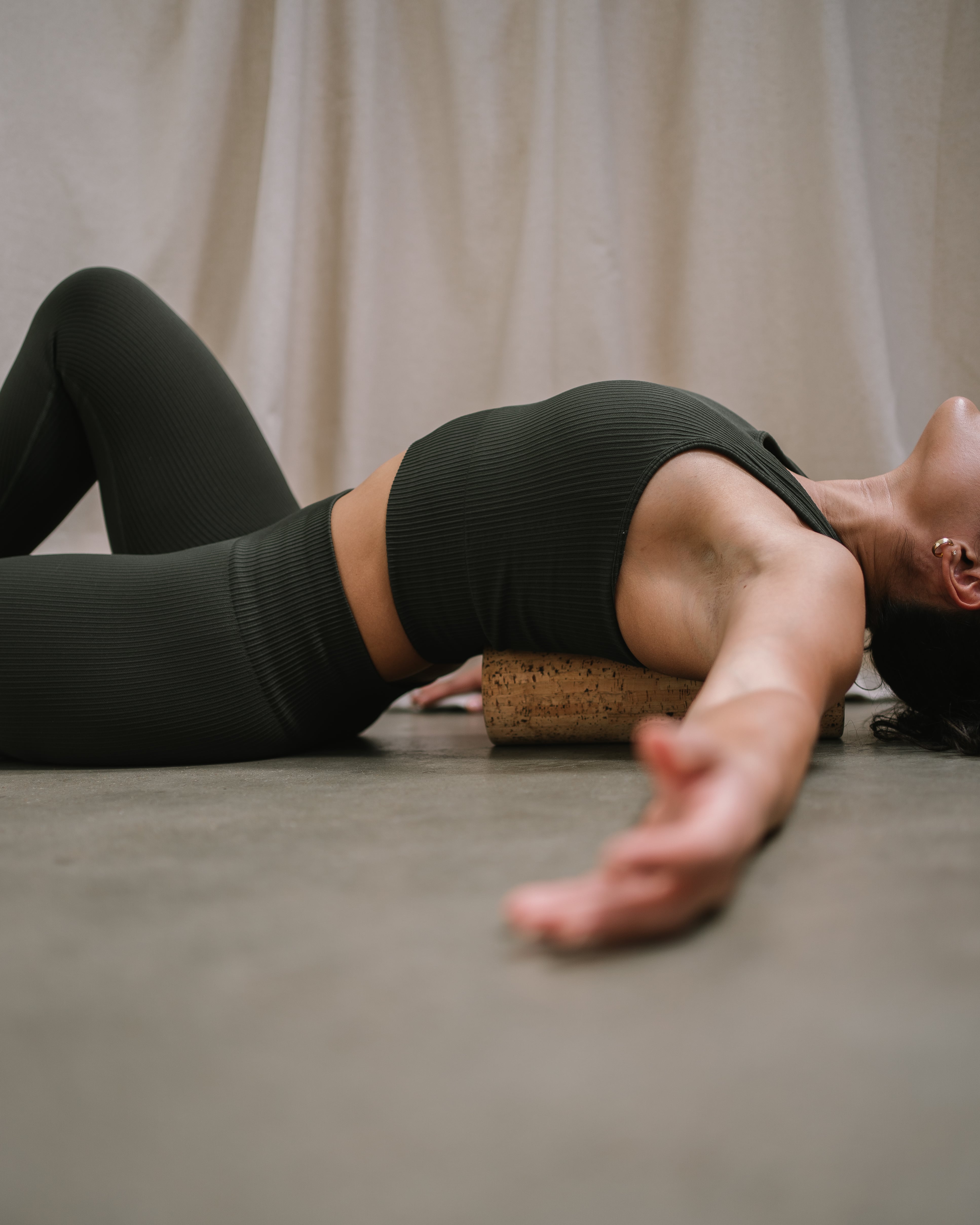 model using a Noveme cork roller to massage her back