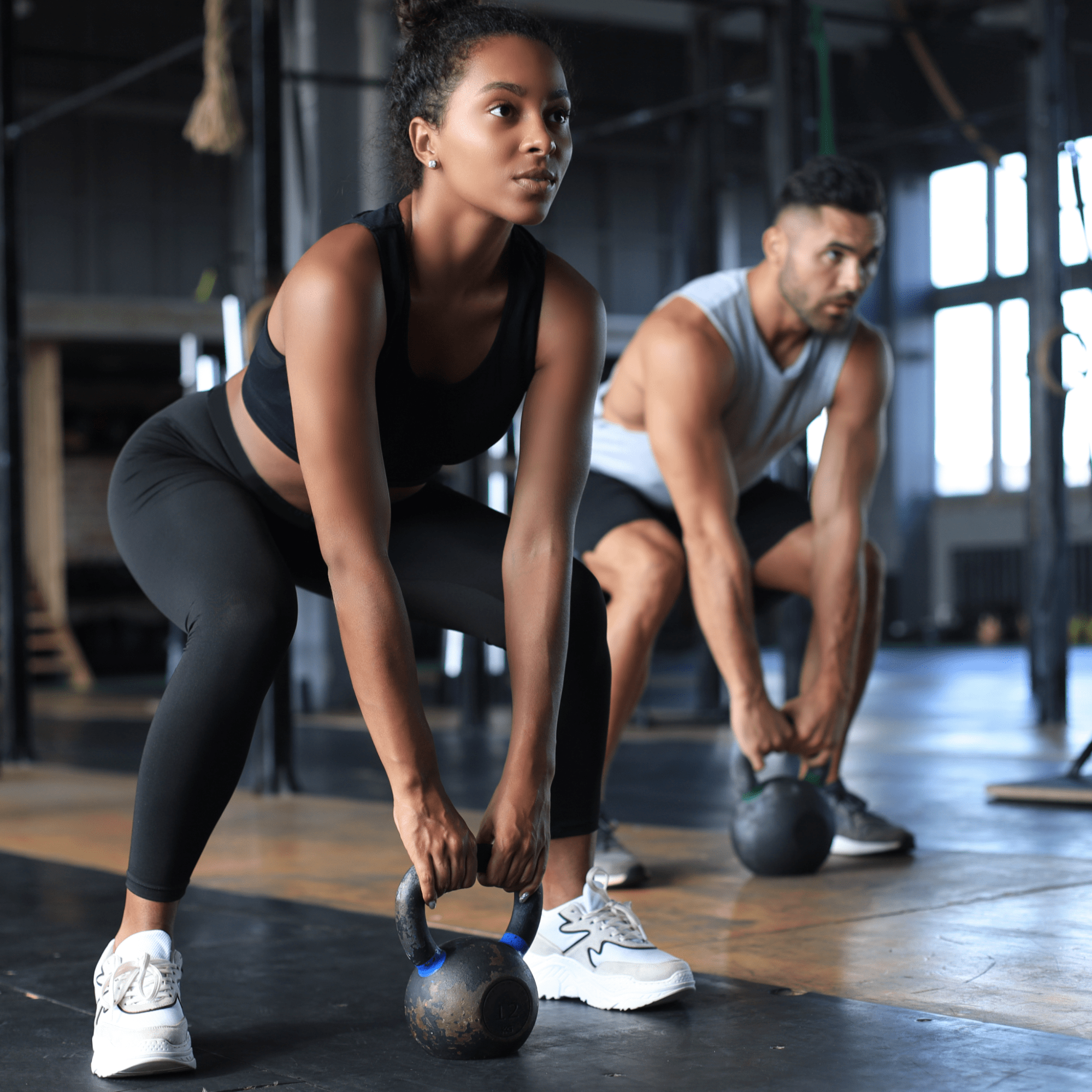 A man and a woman swinging kettlebells | Ultimate Nutrition
