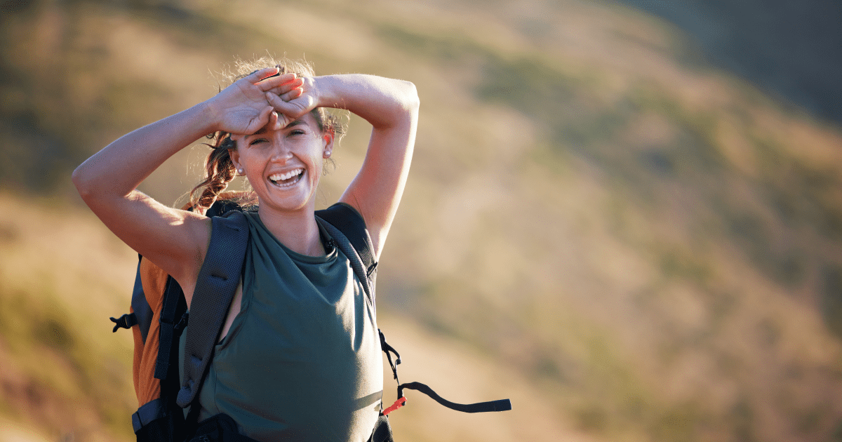 A woman on a trail smiling | Ultimate Nutrition