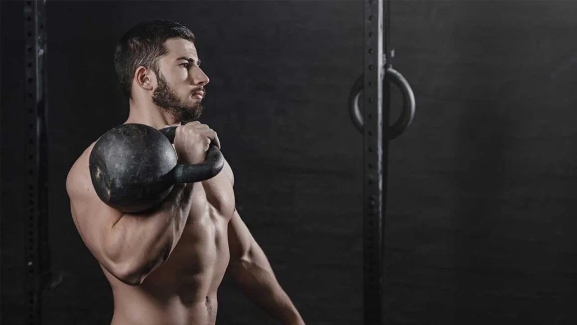 A man performing a kettlebell press