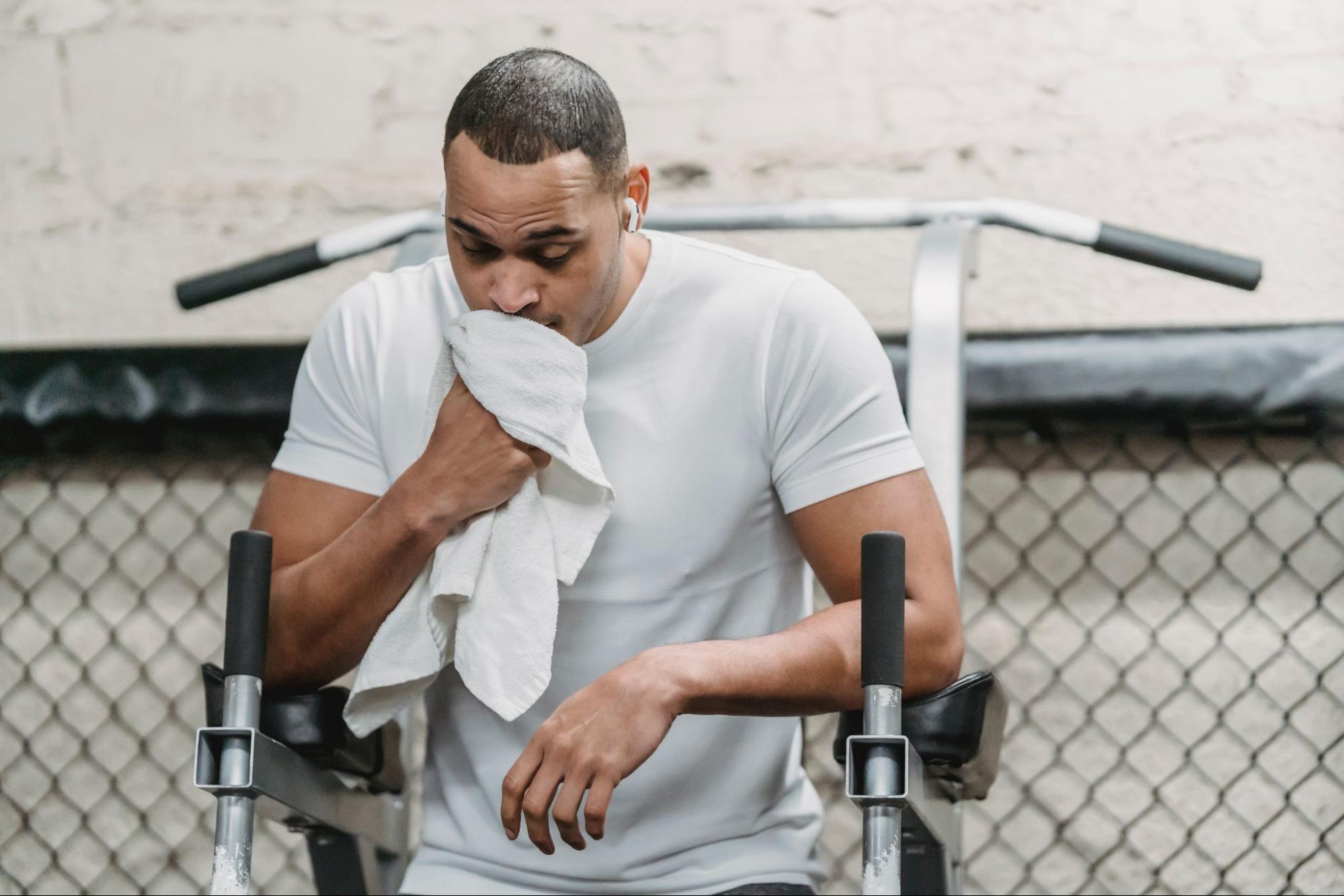 Man wiping sweat off of face after exercising