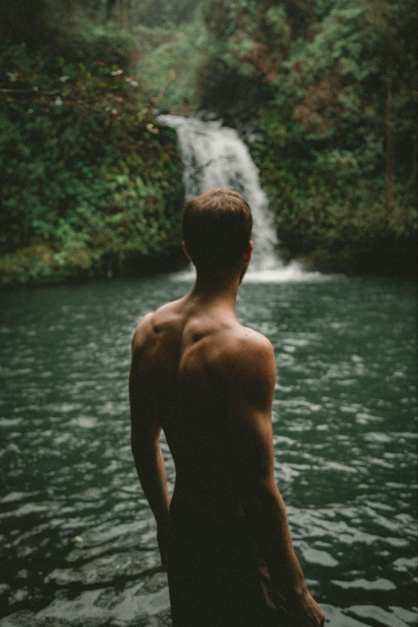 Muscular Man Stands at River