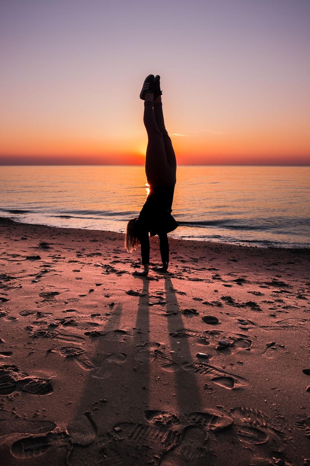 Parada de manos de yoga de playa