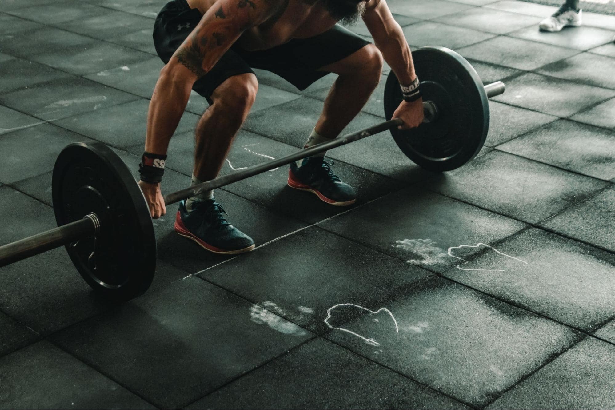 crouched person about to snatch barbell