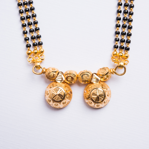 Indian mangalsutra necklace with black glass beading and gold chain for a marriage.