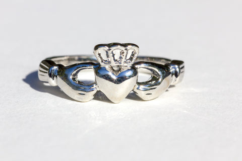 Irish Claddagh Ring in silver in the shape of a heart a crown and hands wrapping around.