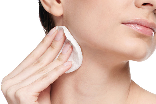 closeup portrait of young woman with perfect skin applying clean cotton to remove makeup