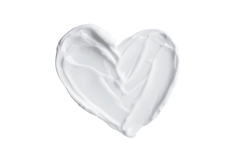 Heart shaped from skincare cream on white background