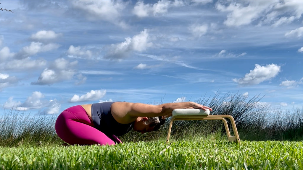 Close-up little girl stretching her body in Balasana pose, sitting