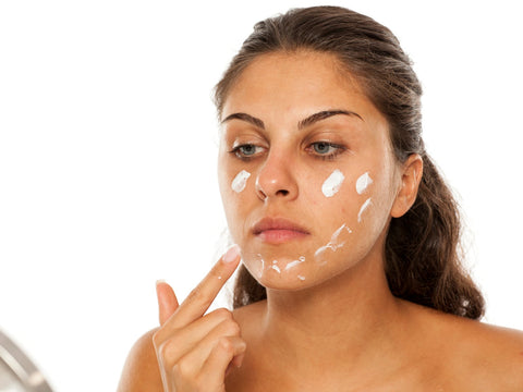 woman moisturising her face 