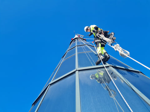 Rope Access professional on glass building wearing Extreme Access workwear