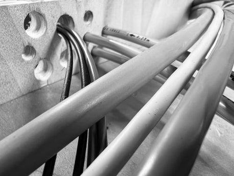 Black and White image showing cables and air lines being routed through a fixture