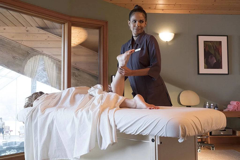 Mazikeen, a brown woman, massages a white women who is laid out on a massage table.