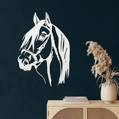 White metal horse head wall art on a dark wall above a wooden cabinet.