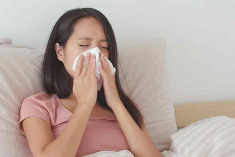 Woman in bed with allergies